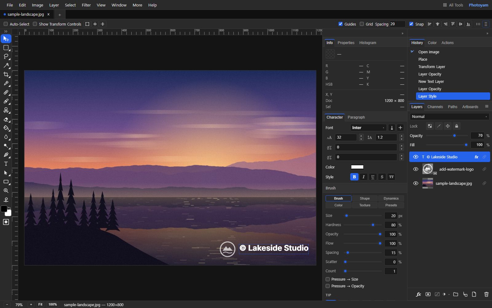 The Photoyam editor with a lake sunset illustration. A white circular mountain logo and the text "© Lakeside Studio" sit in the bottom-right corner. The Layers panel lists the text layer with an fx badge, the placed logo smart object and the photo, with Opacity set to 70%; the History panel shows Place, Transform Layer, Layer Opacity, New Text Layer and Layer Style.